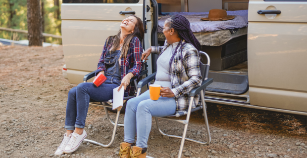 Des femmes âgées multiraciales profitent de leurs vacances en pleine nature près de leur autocaravane.