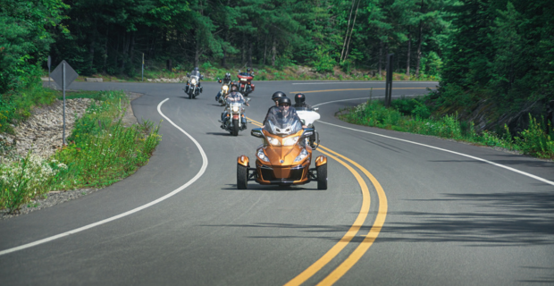 Dans le Parc national de la Mauricie, les motocyclistes roulent en groupe sur une route près du parc. 