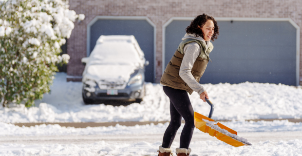 Une femme pelletant de la neige pendant l'hiver.