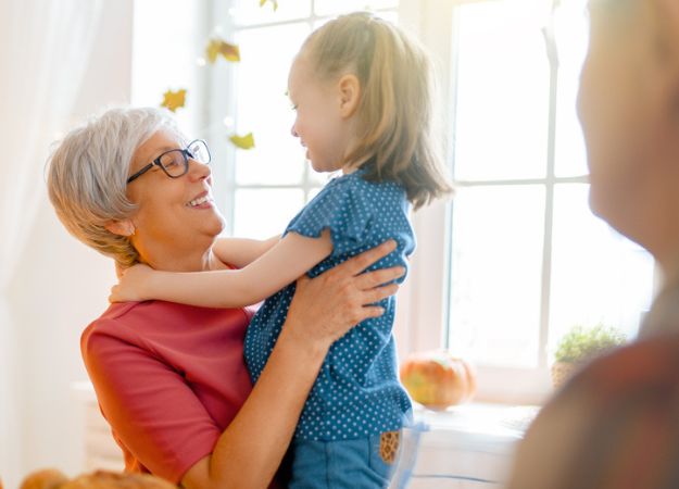 Une grand-mère étreignant sa petite-fille lors d'un dîner en famille.