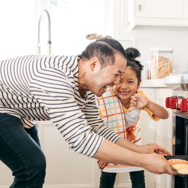 Un Canadien d'origine asiatique et son enfant préparent des biscuits ensemble dans leur nouvelle maison en Alberta.