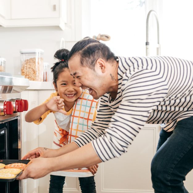 Un Canadien d'origine asiatique et son enfant préparent des biscuits ensemble dans leur nouvelle maison en Alberta.