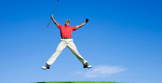 Un golfeur enthousiaste saute de joie après avoir réussi un trou d’un coup.