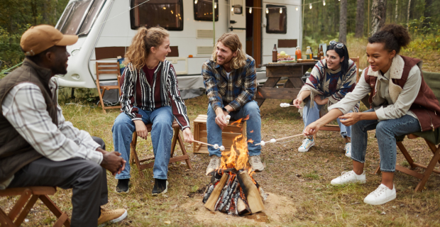 Des campeurs en VR s’installent sur un terrain de camping en respectant les règles de bonne conduite, avec des caravanes garées dans les emplacements désignés.  