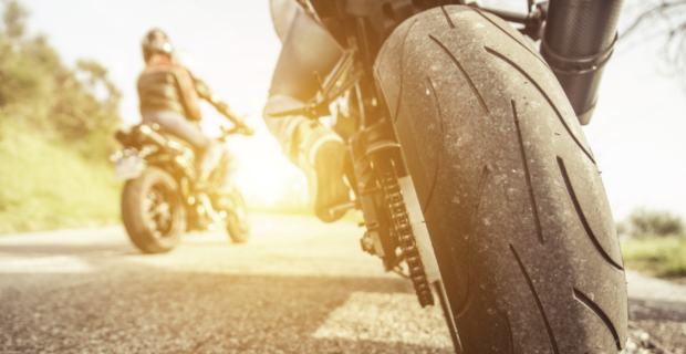 Motocycliste portant un casque et un équipement de protection pour rouler en sécurité à moto en été. 